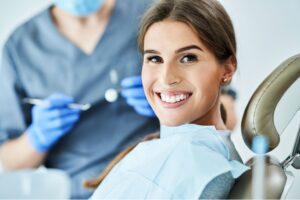 a woman smiling at the camera while getting orthodontic treatment