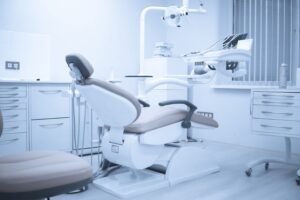 A photo of a dental clinic with chair, lights, cabinets, and other tools